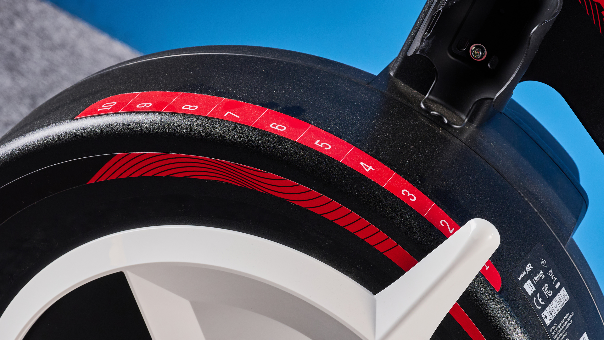 the wattbike air with a black and white front wheel, adjustable seat, and phone holder with app compatibility