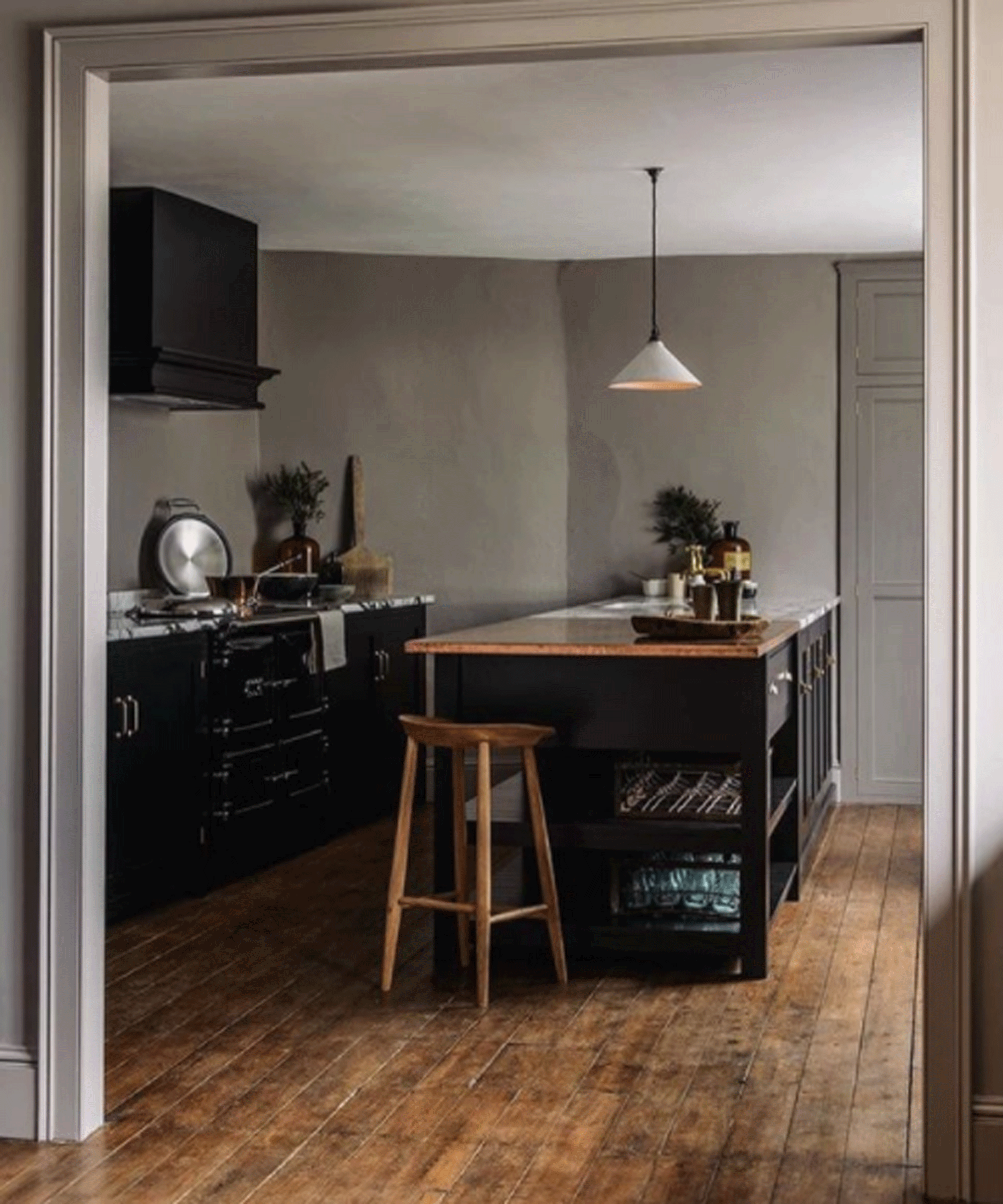 Black kitchen with wooden flooring and grey walls