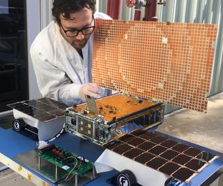 Engineer Joel Steinkraus uses sunlight to test the solar arrays on one of two Mars Cube One (MarCO) spacecraft at NASA's Jet Propulsion Laboratory. The MarCo cubesats "Wall-E" and "Eva" are launching with NASA's InSight Mars lander mission on May 5, 2018.