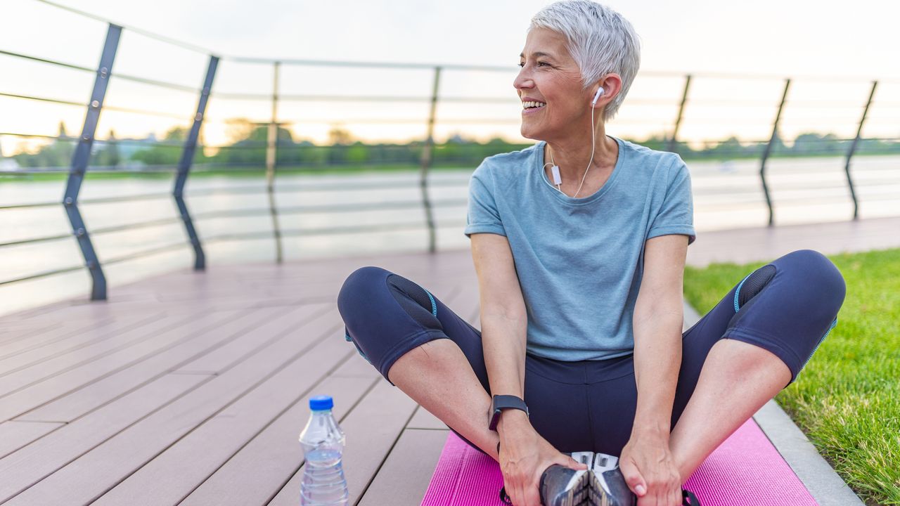 Mature woman stretching after training