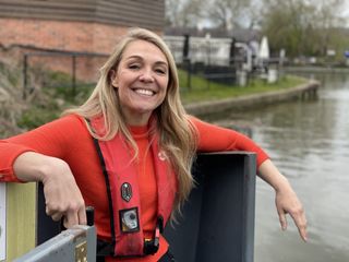 Sophie Morgan sitting by a river wearing a red jumper for Living Wild season 2