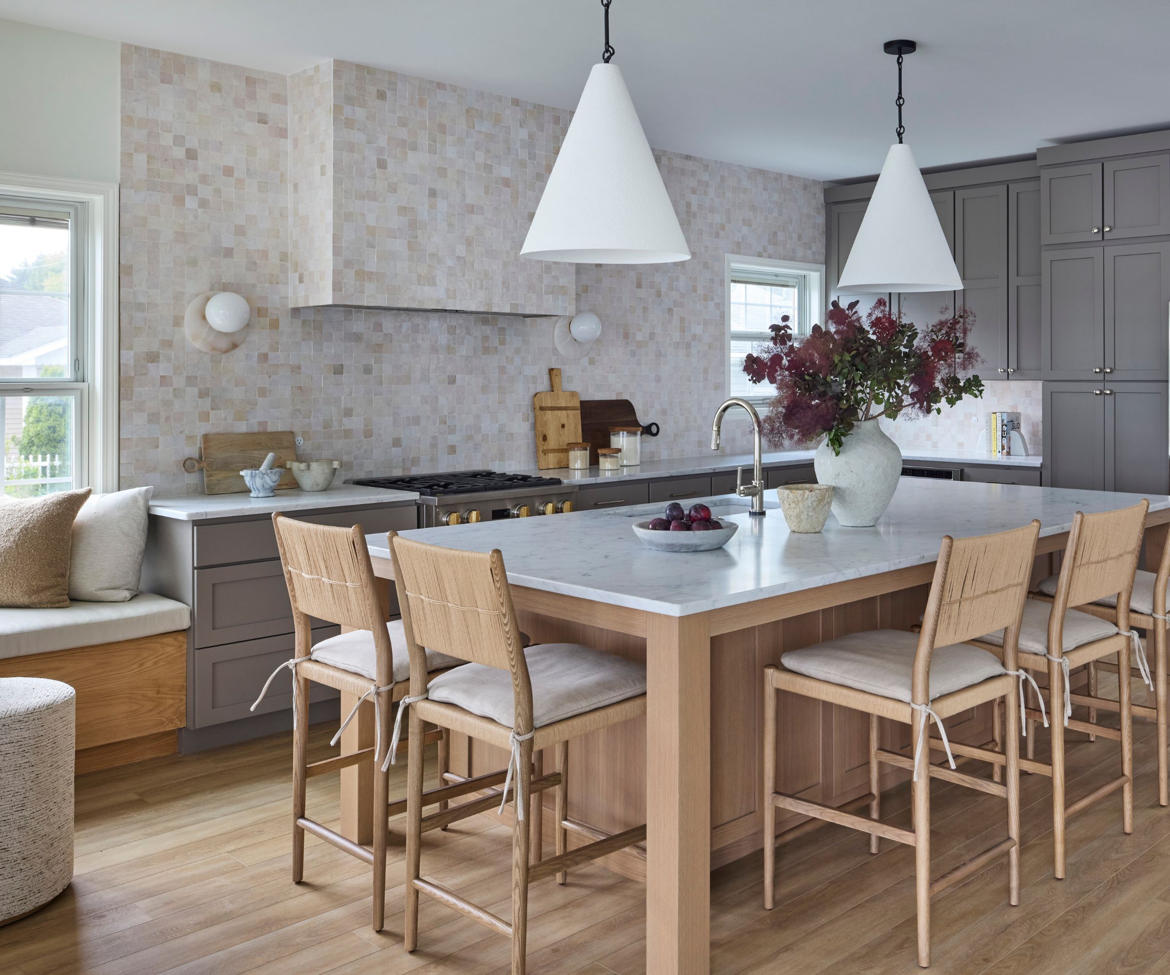 A gray, white, and wood kitchen with a cozy banquette in the corner