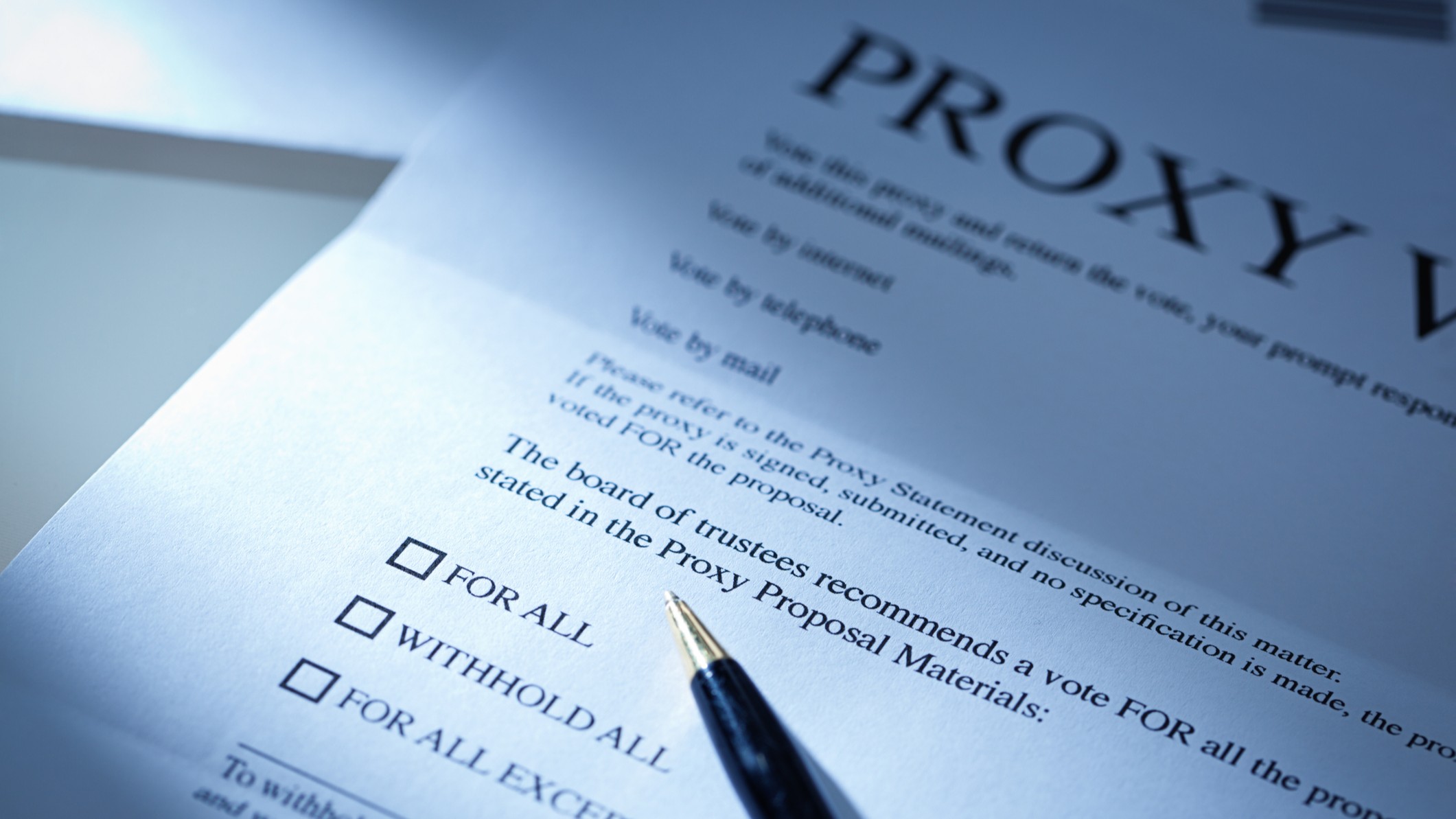 A proxy vote business letter with a pen resting on the document symbolizing a shareholder vote