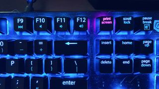 Image of a backlit keyboard, with the print screen button highlighted in pink