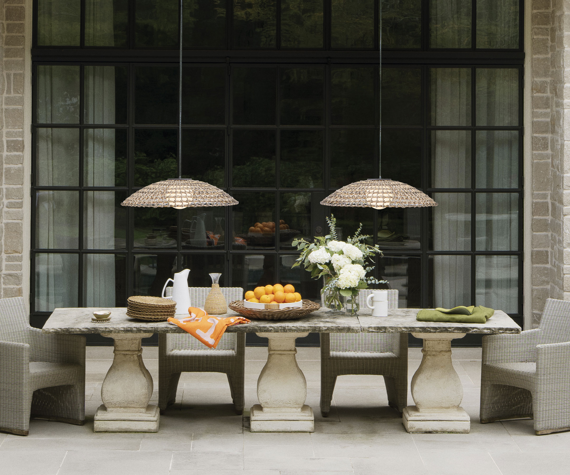 patio with stone dining table and wicker pendant lights