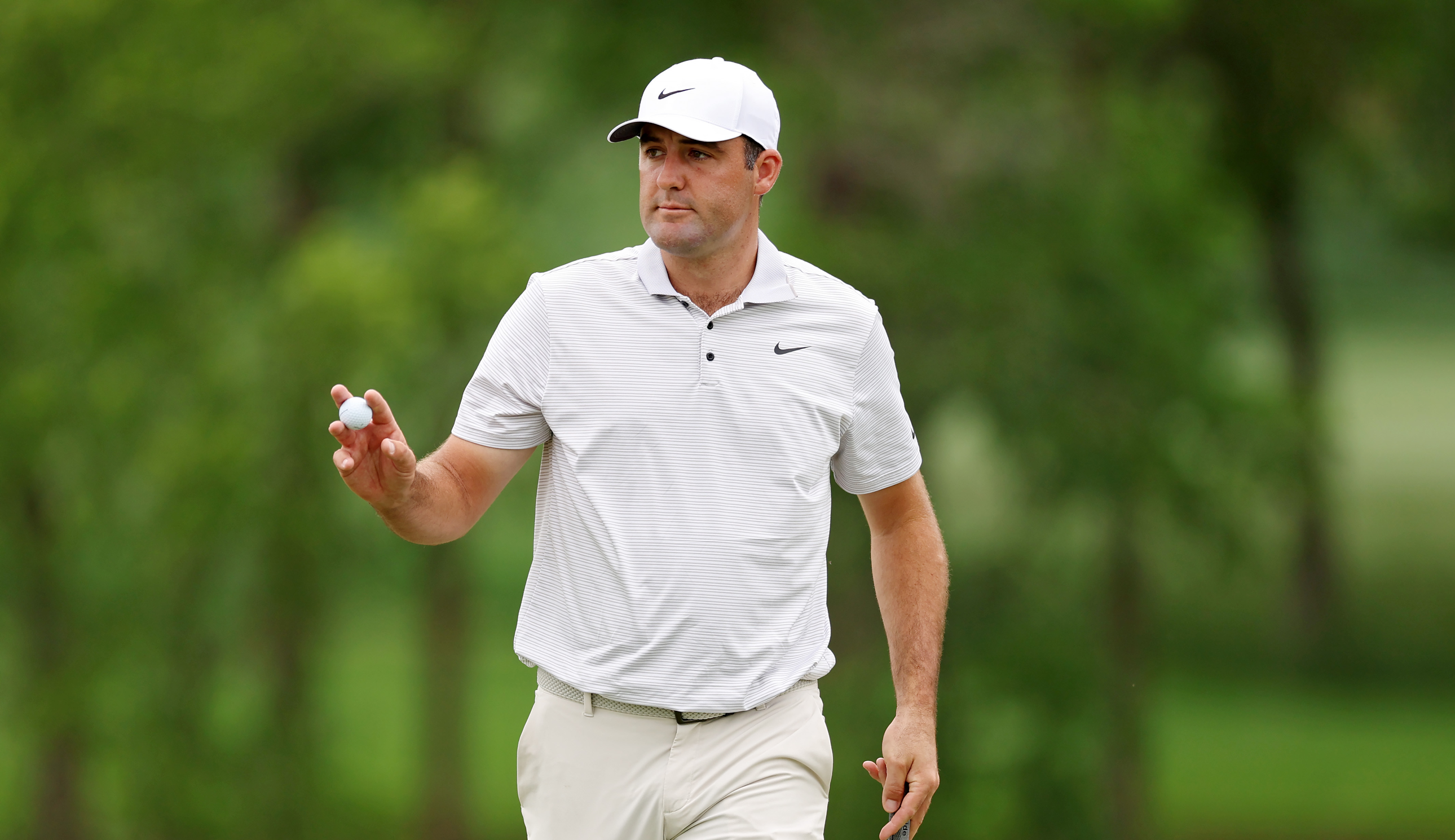 Scottie Scheffler waves to the crowd after holing a putt
