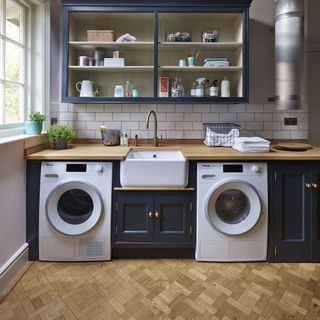Utility room with navy shaker cabinets and parquet flooring.