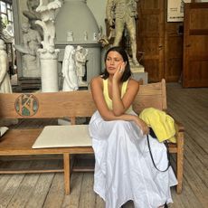 Isabelle Coheen in a yellow tank and cardigan and a white maxi skirt. 