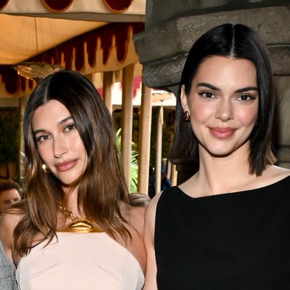 Hailey Bieber wears a nude halter dress while Kendall Jenner has a long bob and wears a black dress