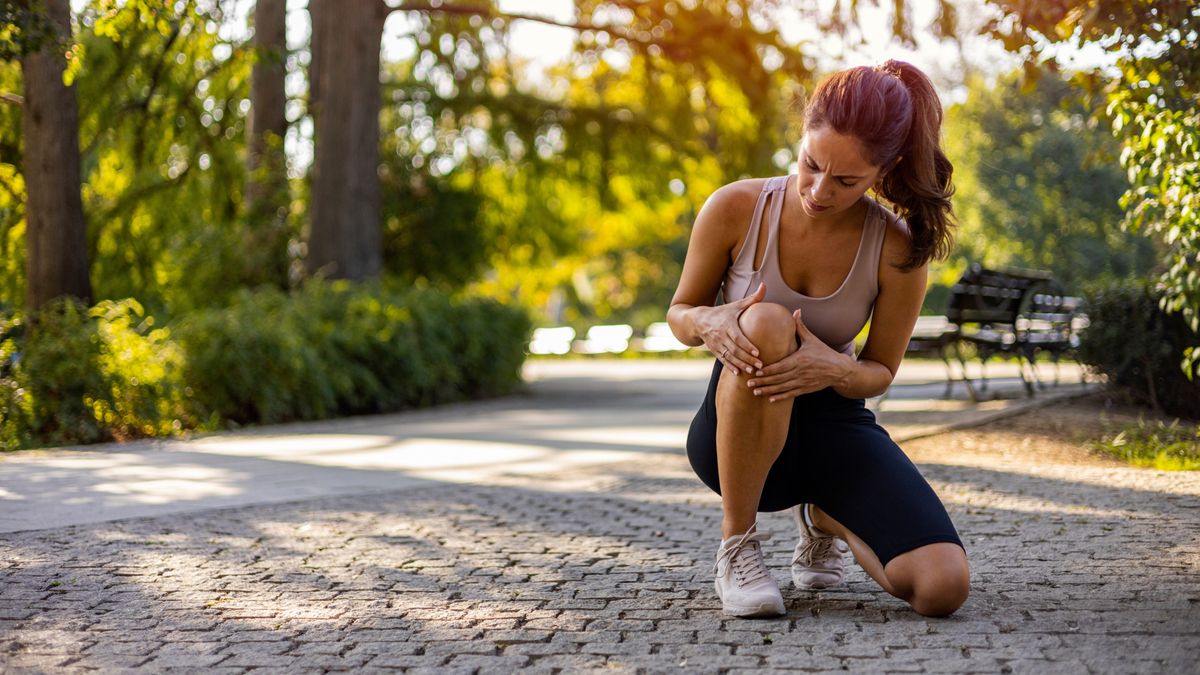 Injured female runner holding knee