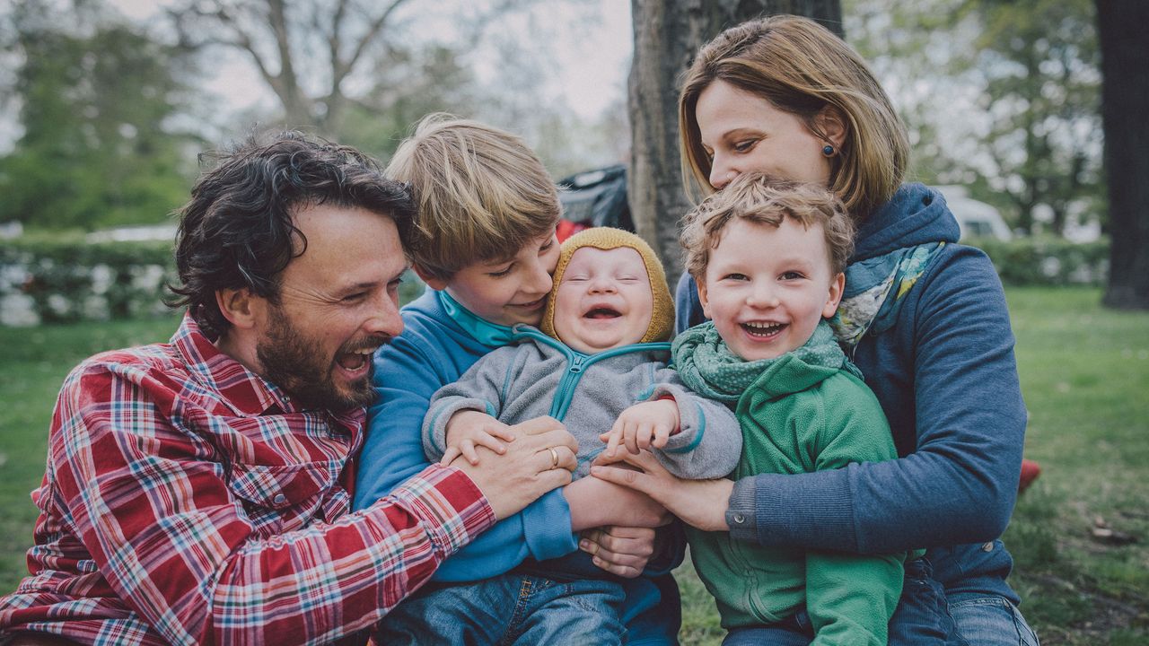 picture of a happy family with three kids outside