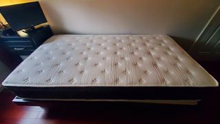 Allswell mattress place on a wooden platform bed during our review process