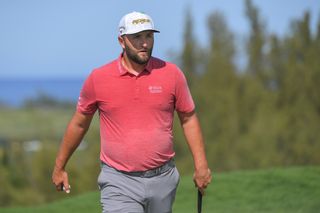 Jon Rahm walks on the green with putter in hand