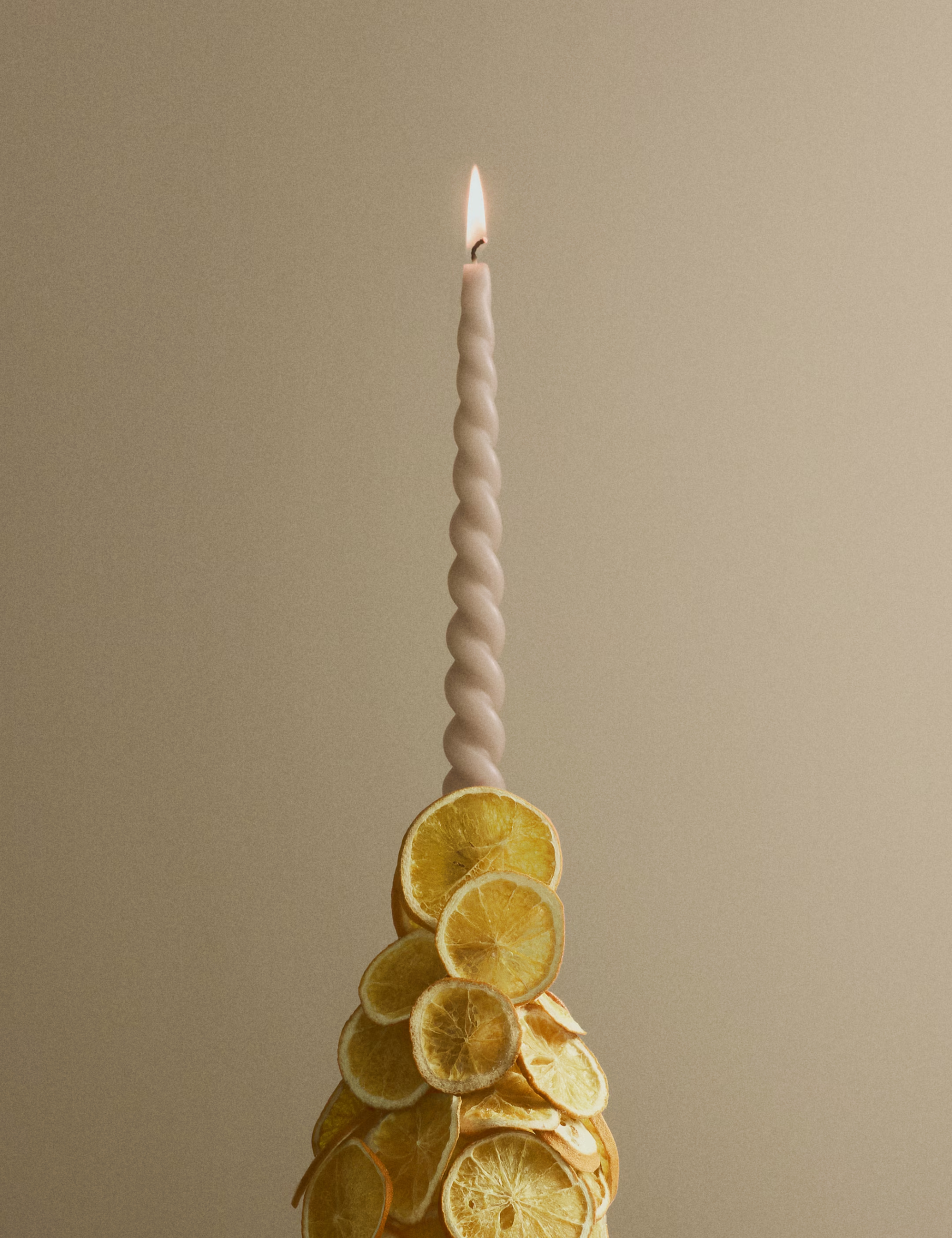 Twisted taper candle styled with a citrus-covered holder