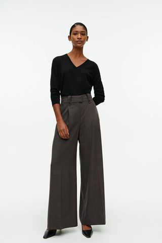 arket sale - woman wearing wide leg tailored grey trousers with black top tucked in