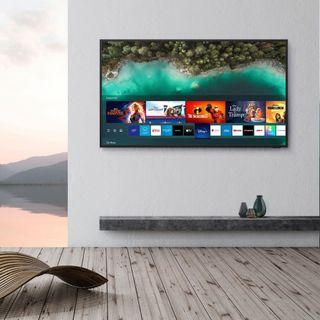 outdoor tv on wall beside a decked area and water or lake background