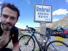 Image of Donald Evans with his bike at the summit of the Umbrail Pass