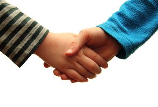 Two kids shake hands.