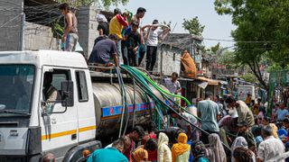 Residents of Snjay Camp in New Delhi fill plastic containers with water from a tanker in June 2026. Severe heatwaves mean that some areas of India&#039;s capital experience water shortages in the summer.