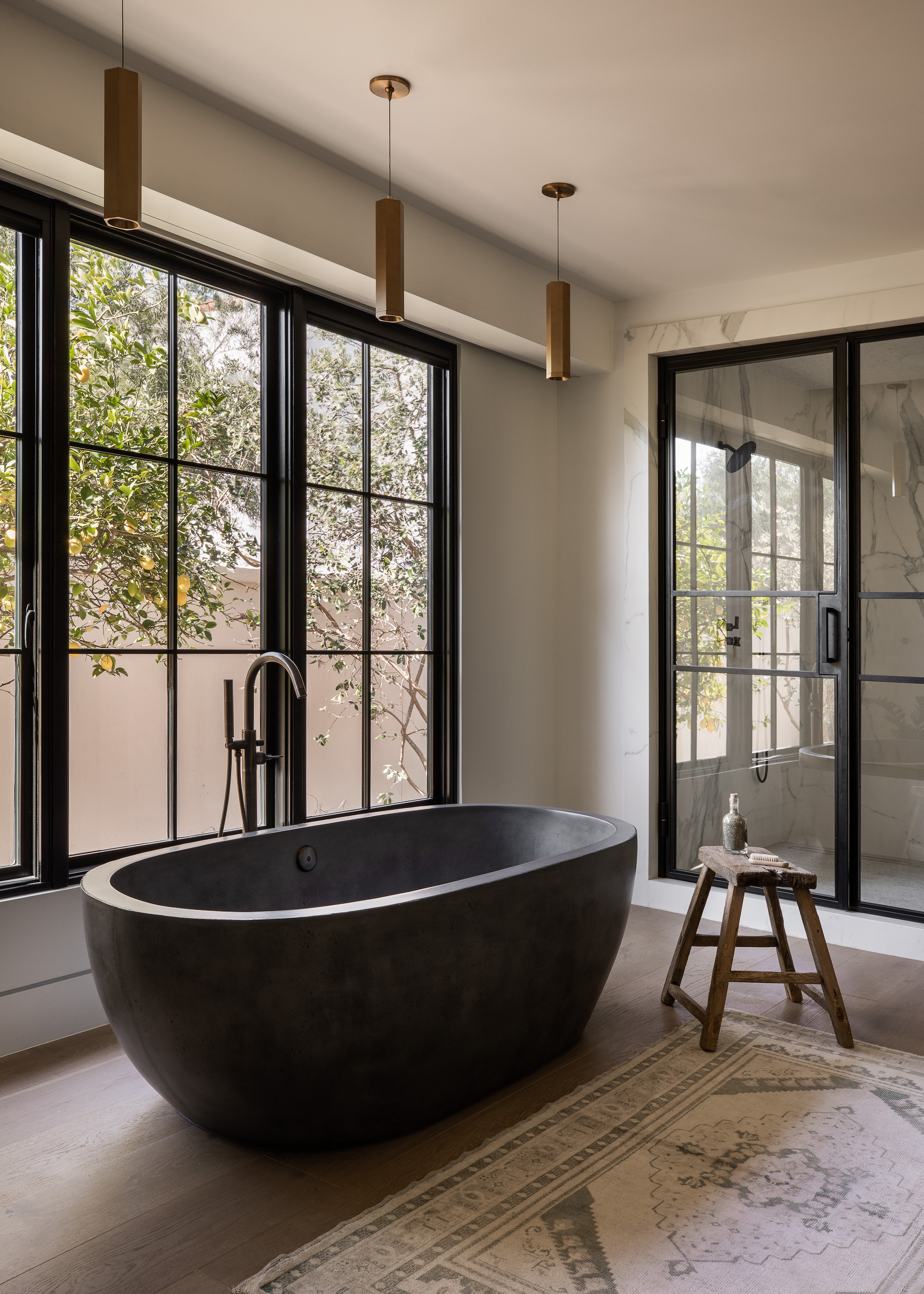 bathroom with black bath and wood floors