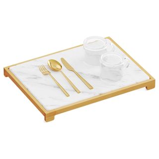 A kitchen drying mat in a raised bamboo holder with gold cutlery on top