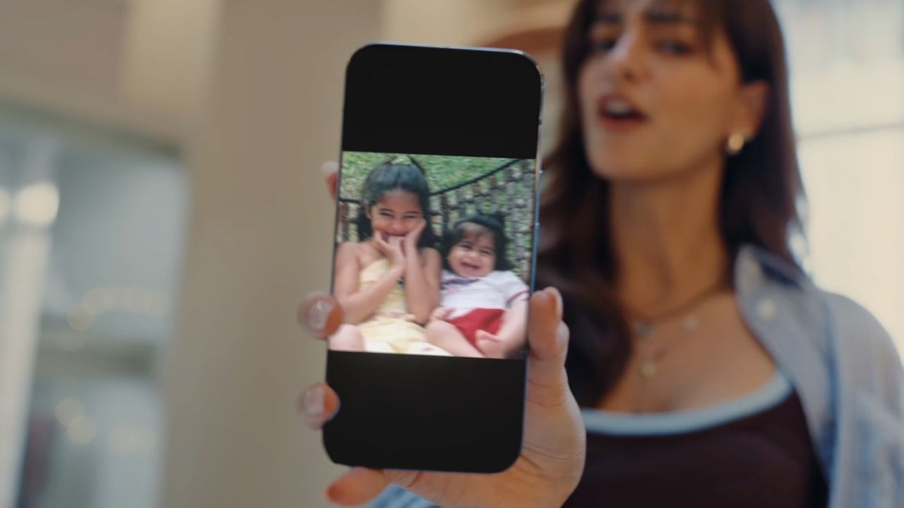 A Pixel phone being held up by a woman, with an image of children on the screen