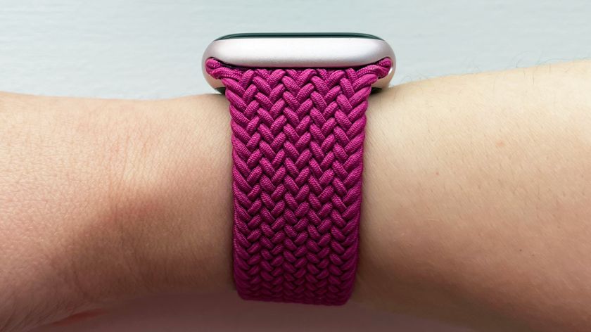 A side view of the magenta-colored Apple Braided Solo Loop attached to a light pink Apple Watch on a woman&#039;s wrist.