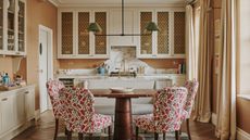 A kitchen with a sofa and chairs placed right next to the island