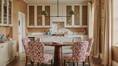 A kitchen with a sofa and chairs placed right next to the island