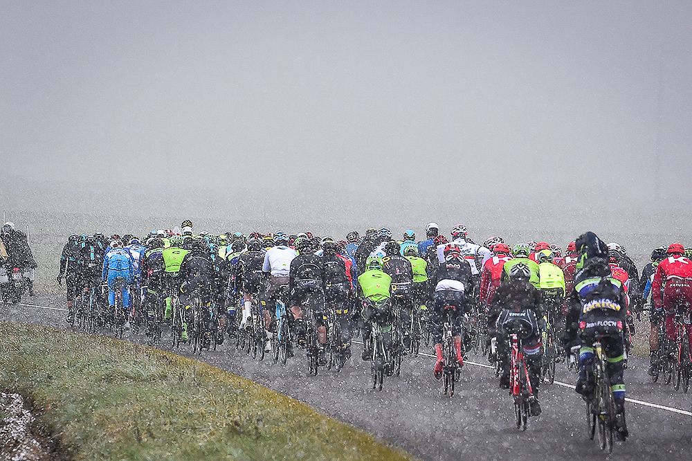 Snow falls on the peloton during stage 1 at Paris-Nice.