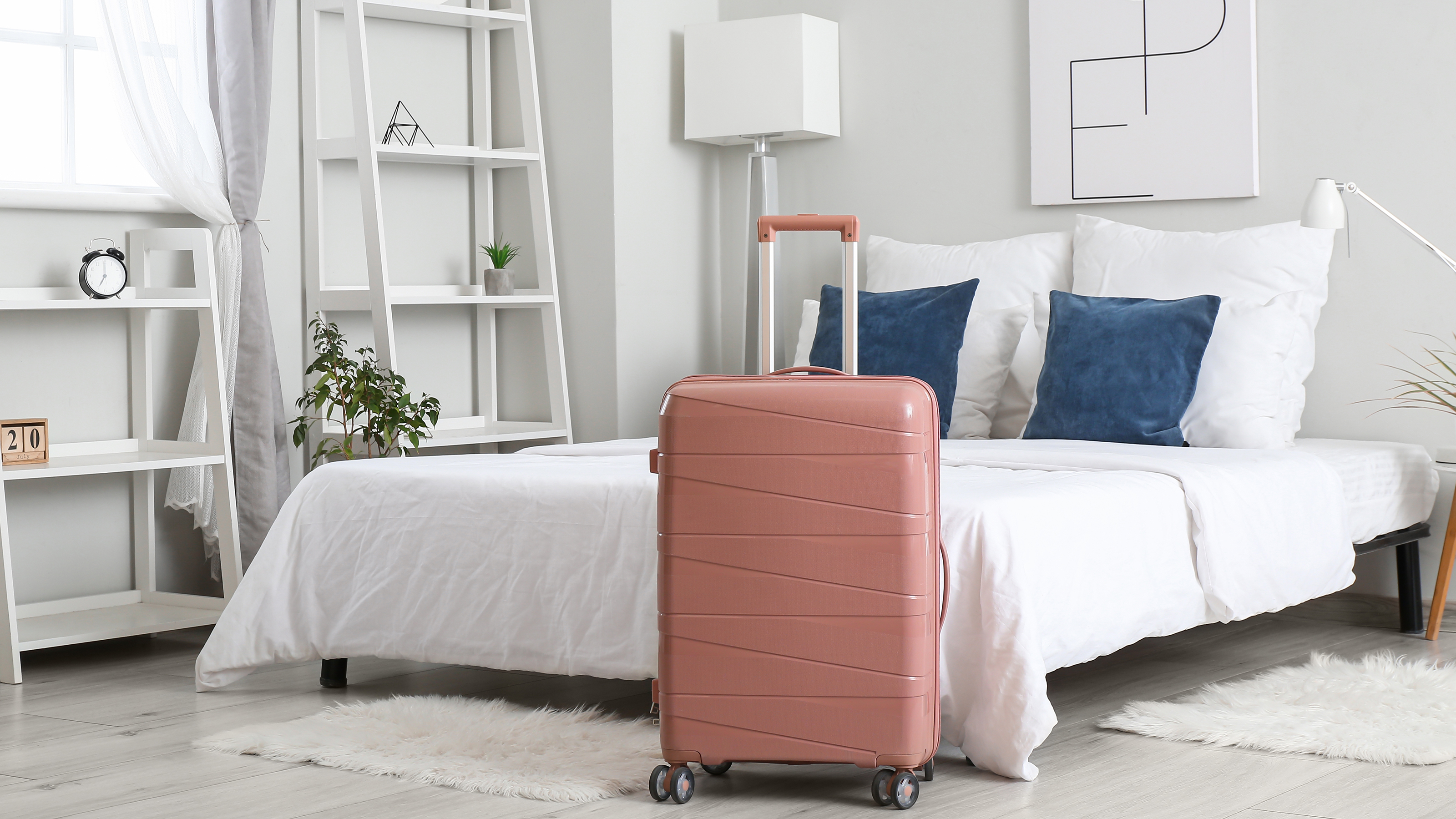 pink suitcase in a white bedroom