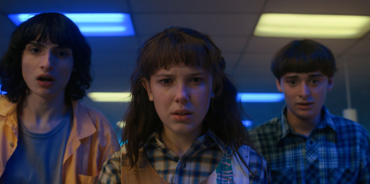 Finn Wolfhard as Mike Wheeler, Millie Bobby Brown as Eleven / Jane Hopper and Noah Schnapp as Will Byers in an official image from Stranger Things season 4