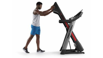 Best folding treadmills: Person folding a Pro-form treadmill on white background