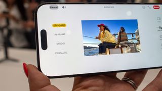 Apple iPhone 16 Pro smartphone held in hand with photo app on screen