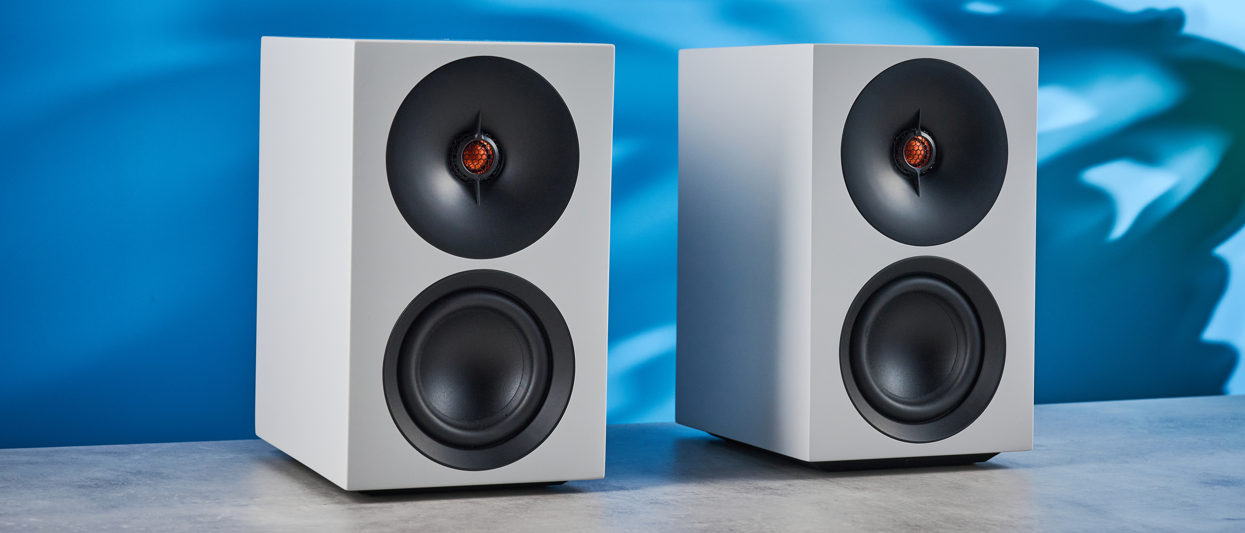the cambridge audio l/r s bookshelf speakers in white with a 21mm aluminum tweeter and a 3-inch woofer photographed against the blue tom's guide background