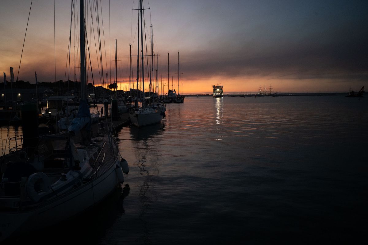 Harbor at last light, there's a distant oncoming ferry
