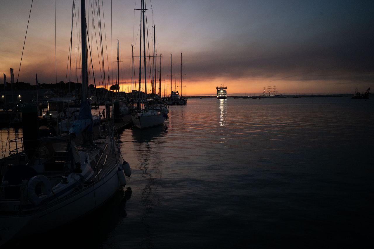 Harbor at last light, there's a distant oncoming ferry