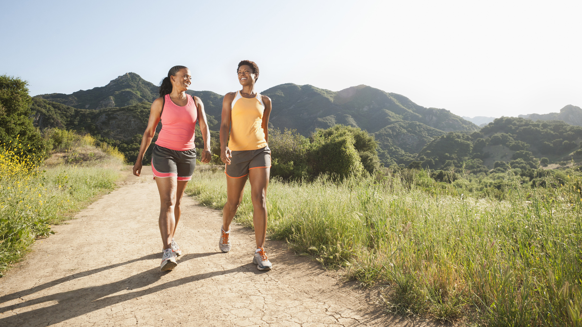 The image shows two women walking