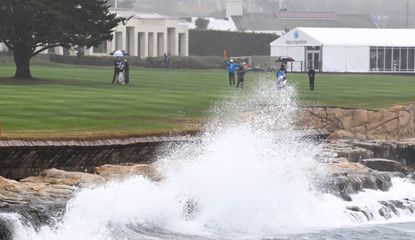 Waves crash against the left hand side of the 18th hole at Pebble Beach