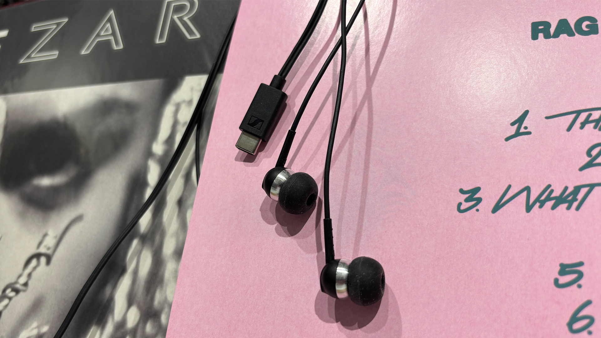 Sennheiser CX 80U wired earbuds lying on vinyl album cover also showing USB-C jack