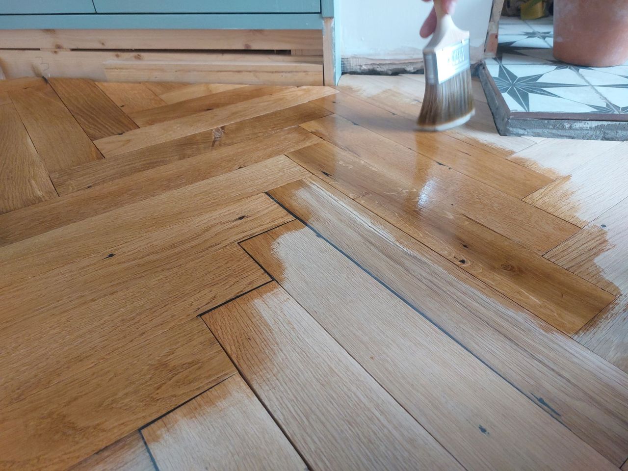 Oiling the floor with a blue wall in the background