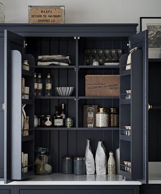 Kitchen Makers Haddon kitchen with dark blue/black cabinets full of kitchen essentials