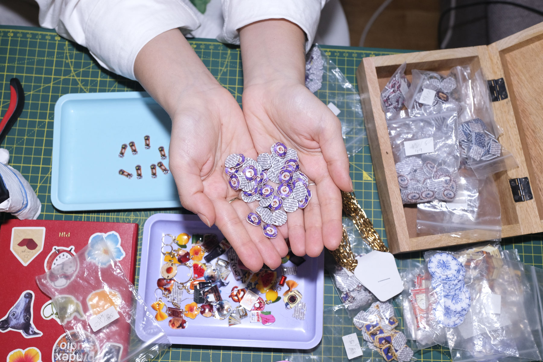 A series of product shots of colorful jewelry, design objects, and fashion accessories, as well as artist portraits of artisans in their busy studios.