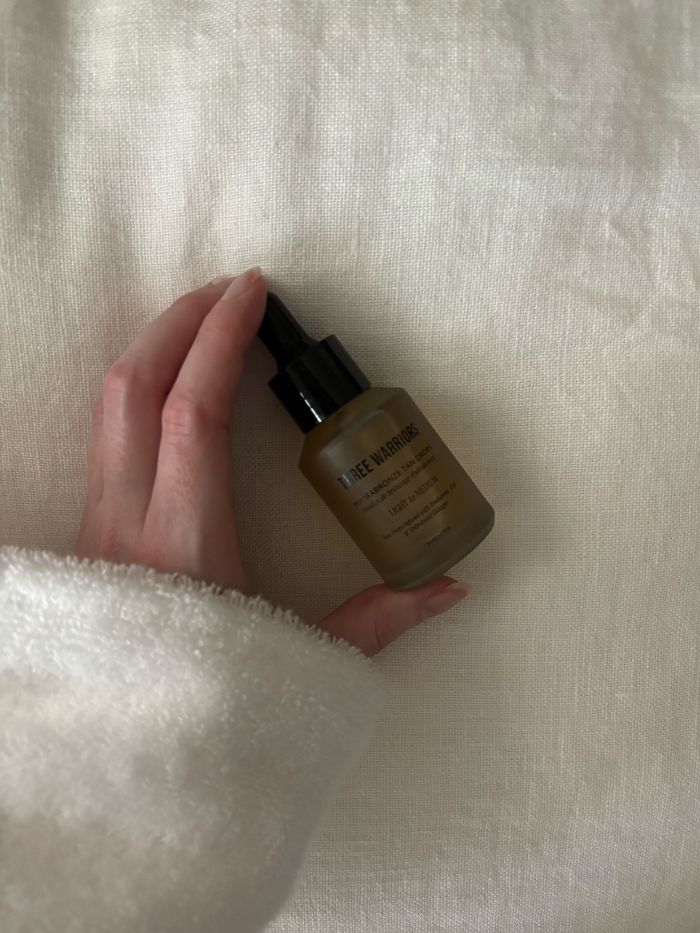 Deputy beauty editor Grace Lindsay holding the Three Warriors Hydrabronze Tan Drops