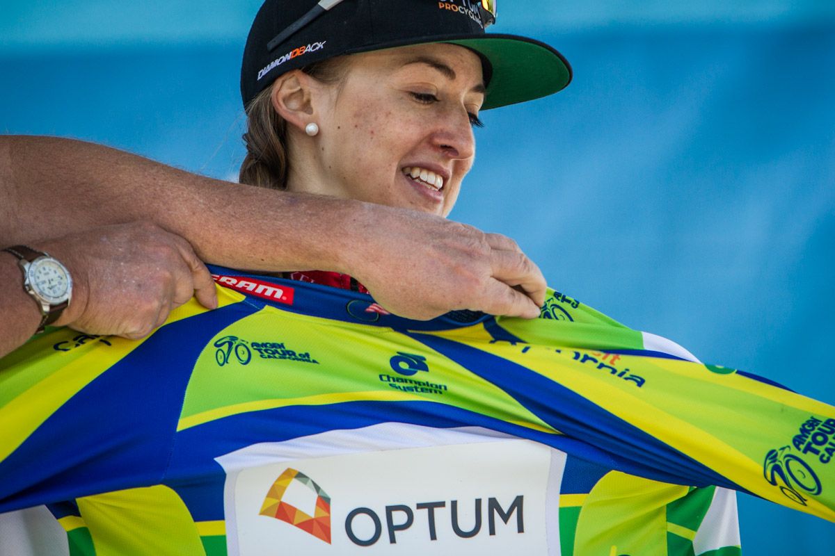 Leah Kirchmann (Optum) gets some help putting on the sprint leaders jersey.