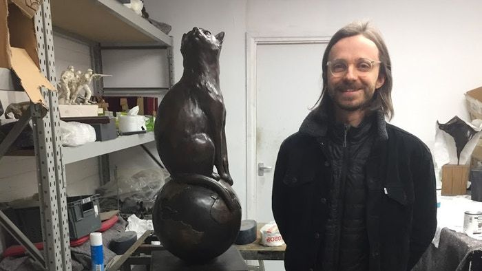 Matthew Serge Guy, who created a fundraising campaign to build a memorial for the first cat in space, poses with the completed statue of F&eacute;licette.