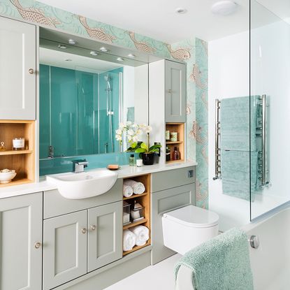 white bathroom with cabinets and blue towels