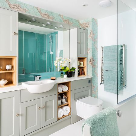 white bathroom with cabinets and blue towels