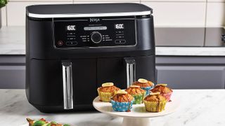 The Ninja Foodi Dual Zone air fryer with some cakes next to it