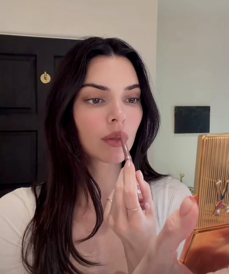 An image of Kendall Jenner applying lip liner.